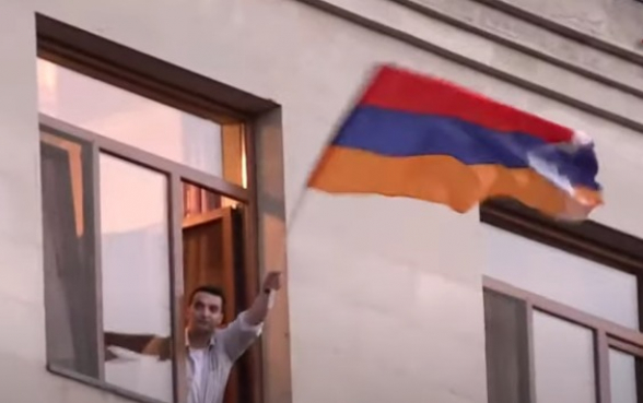 Պատշգամբներից քաղաքացիները ողջունում են երթին՝ ի համերաշխություն պարզում Արցախի դրոշը